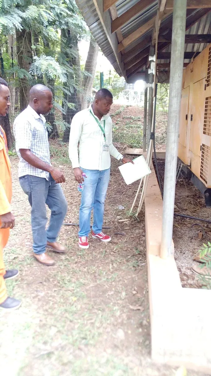 Engineers walking along an equipment shelter to plan an installation