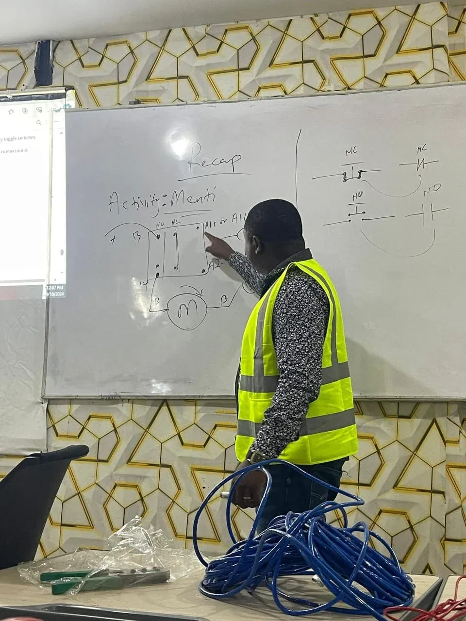 Instructor drawing a motor control circuit on a whiteboard